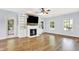 Spacious living room with wood flooring, a fireplace with built-ins, and natural light from two windows at 7380 N 225 W, Lebanon, IN 46052