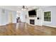 Bright living room featuring hardwood floors, a fireplace with built-in shelving, and large windows at 7380 N 225 W, Lebanon, IN 46052