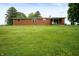 Expansive backyard featuring a well-maintained lawn and a single story brick home with outdoor patio at 8027 S 250 E, Markleville, IN 46056