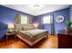 Comfortable bedroom with wood floors, windows allowing natural light, and soothing blue paint at 8027 S 250 E, Markleville, IN 46056