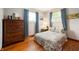 Charming bedroom with wood floors, a colorful bedspread, and two windows covered with patterned curtains at 8027 S 250 E, Markleville, IN 46056
