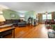 Spacious living room featuring hardwood floors, a large sectional couch, and an adjacent dining area at 8027 S 250 E, Markleville, IN 46056