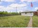 Large backyard featuring green grass, a fenced perimeter, and detached garage at 914 English Ave, Indianapolis, IN 46203