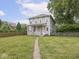 Charming home with front porch, red door, spacious lawn, and mature trees at 914 English Ave, Indianapolis, IN 46203