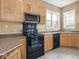 Eat-in kitchen featuring tile flooring, black appliances and light colored cabinets at 914 English Ave, Indianapolis, IN 46203