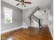 Bright living room boasting gleaming hardwood floors, large window, and classic staircase at 914 English Ave, Indianapolis, IN 46203