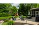 Backyard with a patio seating area around a fire pit, play set and lush green landscaping at 9804 Wentworth Ct, Carmel, IN 46032