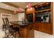 Stylish basement bar with a black countertop, wood cabinets, and modern lighting at 9804 Wentworth Ct, Carmel, IN 46032