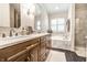 Luxurious bathroom with double vanity, marble accents, soaking tub, and walk-in shower at 9804 Wentworth Ct, Carmel, IN 46032