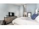 Well-lit bedroom featuring a king-sized bed, neutral tones, and a dresser with a TV at 9804 Wentworth Ct, Carmel, IN 46032