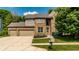 Charming brick two-story home featuring a manicured lawn, mature trees and an attached two-car garage at 9804 Wentworth Ct, Carmel, IN 46032