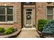 Inviting front entrance featuring a decorative wreath, potted plants, and a well-manicured landscape at 9804 Wentworth Ct, Carmel, IN 46032