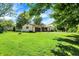 The front of the home features a spacious lawn, mature trees, a long driveway, and attached garage at 101 Heiny Rd, Indianapolis, IN 46217