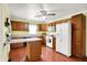 Functional kitchen with oak cabinets, white appliances, and wood-look flooring at 101 Heiny Rd, Indianapolis, IN 46217