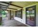 Inviting covered porch with wood floors, glass-paneled doors, and access to the garage at 101 Heiny Rd, Indianapolis, IN 46217