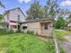 Exterior view of a detached house and overgrown lawn in need of significant repair at 1140 Mcdougal St, Indianapolis, IN 46203