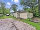 Side view of a detached garage with worn siding, and overgrown grass, along a gravel drive at 1140 Mcdougal St, Indianapolis, IN 46203
