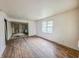Empty living room featuring hardwood floors needing repair, with a window and open doorway at 1140 Mcdougal St, Indianapolis, IN 46203