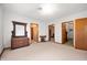 A spacious bedroom with neutral carpet, multiple entryways, and vintage furniture at 1212 Woodlawn Ave, Indianapolis, IN 46203