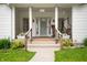 Inviting front porch with white columns, potted plants, and a charming porch swing at 1212 Woodlawn Ave, Indianapolis, IN 46203