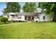 Charming single-story home with a well-manicured lawn and inviting walkway at 1212 Woodlawn Ave, Indianapolis, IN 46203
