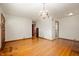 Spacious living room with hardwood floors, neutral walls, and decorative chandelier at 1212 Woodlawn Ave, Indianapolis, IN 46203