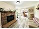 Inviting living room featuring a stone fireplace, light wood floors, and a view into the dining room at 125 W Church St, Thorntown, IN 46071