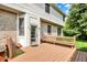 Back deck with a wooden bench and a door leading to the home's interior, surrounded by lush greenery at 1410 Shadow Ct, Zionsville, IN 46077