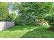 Spacious backyard with lush green grass, mature trees, and a charming wooden fence creating a serene outdoor space at 1410 Shadow Ct, Zionsville, IN 46077