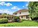 View of a house and a lovely backyard with green grass, mature trees, and a deck at 1410 Shadow Ct, Zionsville, IN 46077