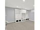 Finished basement area with neutral carpeting and white built-in shelving for storage and decor at 1410 Shadow Ct, Zionsville, IN 46077
