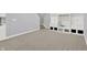 Finished basement area with neutral carpeting, built-in shelving, and stairs to the upper level at 1410 Shadow Ct, Zionsville, IN 46077