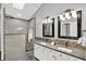 A modern bathroom featuring a double vanity, walk-in shower, decorative tile accents, and stylish lighting fixtures at 1410 Shadow Ct, Zionsville, IN 46077