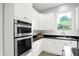 Bright kitchen features white cabinets, stainless steel appliances, and a view to the back yard at 1410 Shadow Ct, Zionsville, IN 46077