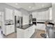 Modern kitchen featuring white cabinets, stainless steel appliances, and a center island at 1410 Shadow Ct, Zionsville, IN 46077