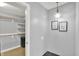 Walk-in closet with an open closet system, chandelier and pictures on the wall with tile flooring at 1410 Shadow Ct, Zionsville, IN 46077