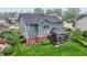An aerial view of a backyard with green grass, a covered deck, and a patio with an outdoor seating area at 15023 Glenmoor Cir, Carmel, IN 46033