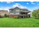 Expansive backyard featuring lush green grass, a large deck, and the home's rear elevation at 15023 Glenmoor Cir, Carmel, IN 46033