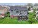 Aerial view showcases a home with a backyard featuring a covered deck, well-maintained lawn, and outdoor seating at 15023 Glenmoor Cir, Carmel, IN 46033