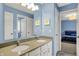 Bright bathroom showcasing double sinks with quartz countertops and views to an adjacent bedroom at 15023 Glenmoor Cir, Carmel, IN 46033