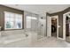 Spacious bathroom features a soaking tub, glass shower enclosure, and natural light at 15023 Glenmoor Cir, Carmel, IN 46033