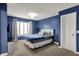 This bedroom features navy blue walls, a bed, and a window offering natural light at 15023 Glenmoor Cir, Carmel, IN 46033