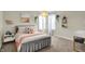 This is a bright bedroom with white walls, a large bed, and a desk that offers style and comfort at 15023 Glenmoor Cir, Carmel, IN 46033