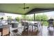 Spacious covered deck featuring dining and lounge seating, ceiling fan, and a dark wood floor at 15023 Glenmoor Cir, Carmel, IN 46033