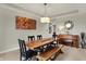 Dining room boasting a rustic table, unique artwork, and a charming piano at 15023 Glenmoor Cir, Carmel, IN 46033