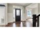 Welcoming entryway with dark wood floors, wainscoting, and a decorative front door at 15023 Glenmoor Cir, Carmel, IN 46033