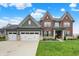 Beautiful two-story brick home featuring a three-car garage and well-manicured lawn at 15023 Glenmoor Cir, Carmel, IN 46033