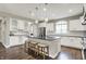 Bright kitchen featuring white cabinets, stainless steel appliances, and a kitchen island with breakfast bar at 15023 Glenmoor Cir, Carmel, IN 46033