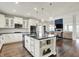 Open kitchen with white cabinets, stainless steel appliances, a large island, and seamless flow to dining and living areas at 15023 Glenmoor Cir, Carmel, IN 46033