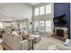 Open-concept living room featuring a stone fireplace, large windows, and seamless transition to the kitchen at 15023 Glenmoor Cir, Carmel, IN 46033